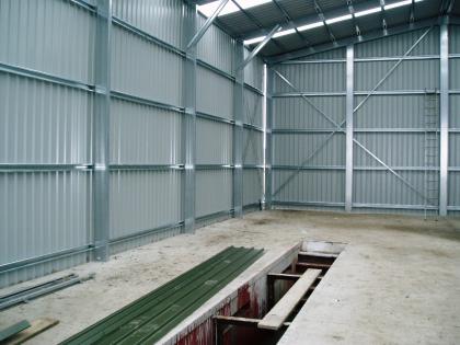 Interior view of the building showing the steel frame and the vehicle inspection pit