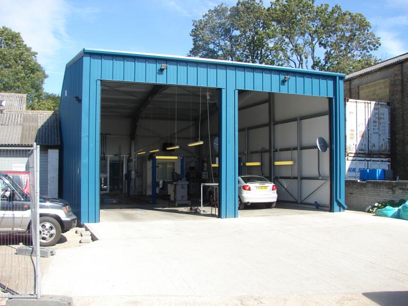 front view of steel framed MOT testing station in blue steel with full steel roller doors